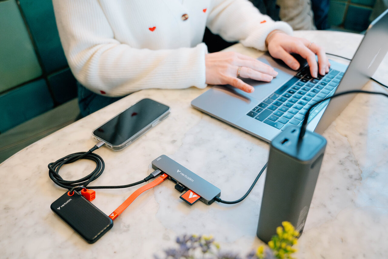 Concentrador USB conectado a un portátil, cargador, SSD y cargando un iphone