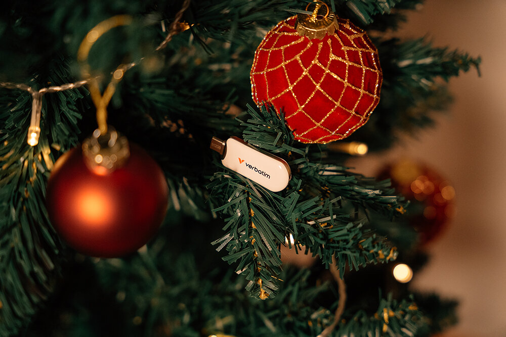 Dallarında beyaz bir USB bellek bulunan süslü Noel Ağacı