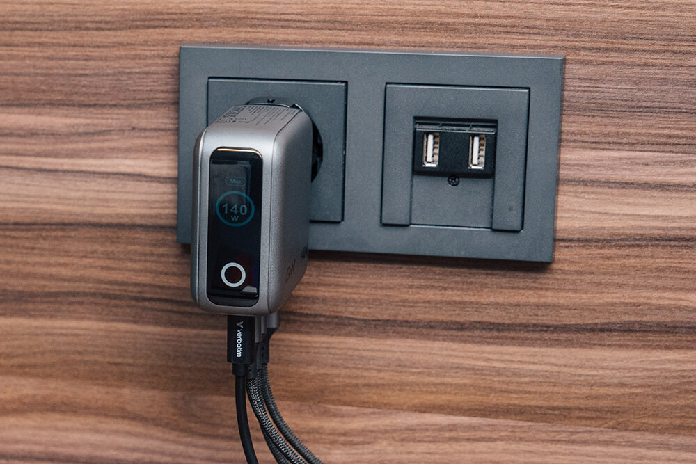 Mini GaN Charger with Display plugged into a socket showing 140W power on the display.