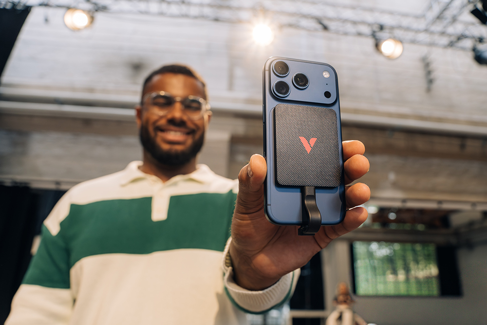 Muškarac drži iPhone s priključenim Snapback UltraSlim SSD-om